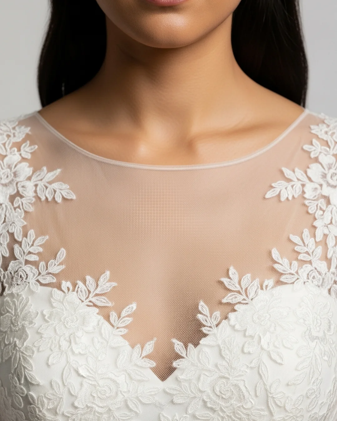 Detalle frontal de un escote ilusión con tul transparente y encaje sobre el pecho en un vestido de novia
